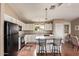 Bright kitchen featuring white cabinets, an island with bar stools, and wood-look floors at 1806 N 108Th Ave, Avondale, AZ 85392