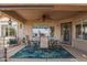 Relaxing covered patio with ceiling fan and scenic backyard view; perfect for outdoor dining and entertaining at 1806 N 108Th Ave, Avondale, AZ 85392