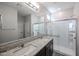 Bathroom featuring dual sinks, granite countertop and spacious shower with glass door at 18171 W Daley Ln, Surprise, AZ 85387
