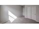 This bedroom provides neutral carpet and walls, white closet, and door, bathed in light, creating a serene retreat at 18171 W Daley Ln, Surprise, AZ 85387
