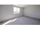 Bright bedroom featuring a large window and neutral carpeting at 18171 W Daley Ln, Surprise, AZ 85387