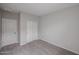 A cozy bedroom offers neutral walls, carpet, closet, and a paneled door for a clean, minimalist design at 18171 W Daley Ln, Surprise, AZ 85387