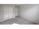 A bedroom with a closet and carpet, painted light gray, and features a white door at 18171 W Daley Ln, Surprise, AZ 85387