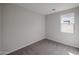 An empty bedroom with a window features carpet and neutral painted walls at 18171 W Daley Ln, Surprise, AZ 85387