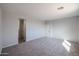 Neutral bedroom showcasing soft carpet and access to bathroom and closet at 18171 W Daley Ln, Surprise, AZ 85387