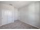 This bedroom provides neutral carpet and walls, two closets and a door, creating a serene retreat at 18171 W Daley Ln, Surprise, AZ 85387