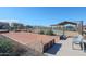 Community bocce ball court alongside desert landscaping and a metal park bench with tennis courts nearby at 18171 W Daley Ln, Surprise, AZ 85387