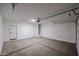 Clean, empty garage with a side door, ready for a car and other storage at 18171 W Daley Ln, Surprise, AZ 85387