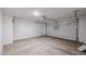 The garage has a concrete floor and a white garage door with a motorized lift and white walls and ceiling at 18171 W Daley Ln, Surprise, AZ 85387