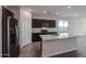 Well-lit kitchen with stainless steel appliances, granite countertops, and a convenient kitchen island at 18171 W Daley Ln, Surprise, AZ 85387