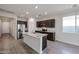 Bright kitchen featuring stainless steel appliances, a kitchen island, and wood-look tile flooring at 18171 W Daley Ln, Surprise, AZ 85387