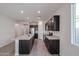 Spacious kitchen featuring stainless appliances, dark cabinets, an island, and tiled floors at 18171 W Daley Ln, Surprise, AZ 85387