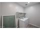 Bright laundry room with a modern washer and dryer, ample shelving, and a glass door, perfect for efficient chores at 18171 W Daley Ln, Surprise, AZ 85387