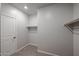 A modern walk-in closet featuring built-in shelving, gray walls, and a white door at 18171 W Daley Ln, Surprise, AZ 85387