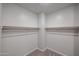 A walk-in closet shows ample storage space with shelves and neutral carpet at 18171 W Daley Ln, Surprise, AZ 85387