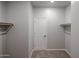 A closet with a door, shelving, neutral carpeting, and painted gray walls at 18171 W Daley Ln, Surprise, AZ 85387