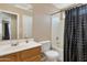 Well-lit bathroom features a vanity, toilet, and shower with stylish polka-dot shower curtain at 18601 N 16Th Pl, Phoenix, AZ 85024