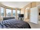 Light bedroom with a bay window, TV, and doorway to the bathroom at 18601 N 16Th Pl, Phoenix, AZ 85024