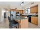 A lovely kitchen with a dark countertop island, light wood cabinets, stainless steel appliances and tile flooring at 18601 N 16Th Pl, Phoenix, AZ 85024