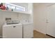 Functional laundry room equipped with a washer, a dryer, built-in shelving and neutral color walls at 18601 N 16Th Pl, Phoenix, AZ 85024