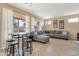 A spacious living room with a gray sectional sofa, tiled flooring, and large windows providing natural light at 18601 N 16Th Pl, Phoenix, AZ 85024