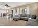 Open-concept living room featuring a gray sectional sofa, tiled flooring, natural light, and a view of the dining area at 18601 N 16Th Pl, Phoenix, AZ 85024