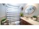 Cozy bathroom featuring a shower with a patterned curtain, a decorative mirror, and a dark wood vanity at 18829 N 23Rd Ave, Phoenix, AZ 85027