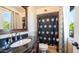 Elegant bathroom with a dark granite countertop, vanity, decorative mirror, and a window providing natural light at 18829 N 23Rd Ave, Phoenix, AZ 85027