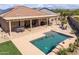 Backyard oasis boasting a covered patio, desert landscaping, and a refreshing pool with sunbathing area at 24127 N 166Th Ct, Surprise, AZ 85387