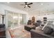 Open-concept living room featuring a sliding glass door, ceiling fan and access to the kitchen at 24127 N 166Th Ct, Surprise, AZ 85387
