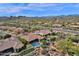 Stunning aerial perspective of a desert neighborhood, highlighting homes with private pools against a mountainous backdrop at 26521 N 114Th Pl, Scottsdale, AZ 85255