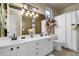 Bathroom featuring double sinks, white cabinets, and ample counter space at 26521 N 114Th Pl, Scottsdale, AZ 85255