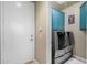 Well-equipped laundry room with modern washer and dryer, and stylish blue cabinetry for storage at 26521 N 114Th Pl, Scottsdale, AZ 85255