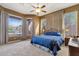 Spacious main bedroom with large windows overlooking the pool, a ceiling fan, and plush carpeting at 26521 N 114Th Pl, Scottsdale, AZ 85255