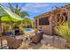 Cozy backyard patio with outdoor fireplace, comfortable seating, and serene views of the desert landscape at 26521 N 114Th Pl, Scottsdale, AZ 85255