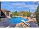Gorgeous swimming pool with a diving board surrounded by a stone patio and lush desert landscaping at 26521 N 114Th Pl, Scottsdale, AZ 85255