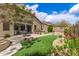 Beautifully landscaped backyard with patio, outdoor kitchen, fire pit and lush green lawn at 27315 N 83Rd Dr, Peoria, AZ 85383