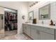 Well-lit bathroom featuring double sinks, modern fixtures, and an organized walk-in closet for ample storage at 27315 N 83Rd Dr, Peoria, AZ 85383