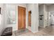 Inviting entryway with tile flooring, a wooden front door, and access to the laundry room at 27315 N 83Rd Dr, Peoria, AZ 85383