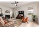 Cozy living room with a fireplace, tile flooring, and comfortable seating near bright windows at 27315 N 83Rd Dr, Peoria, AZ 85383