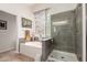 Main bathroom featuring a bathtub, a glass-enclosed shower, and modern fixtures at 27315 N 83Rd Dr, Peoria, AZ 85383