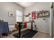 Functional office space with an adjustable desk, unique decor, and ample storage for creative projects at 27315 N 83Rd Dr, Peoria, AZ 85383
