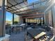 Inviting outdoor patio with a covered pergola, featuring bar seating, tables, and chairs for relaxing or entertaining guests at 27315 N 83Rd Dr, Peoria, AZ 85383