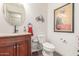 Powder room features a granite countertop vanity, oval mirror, and a themed art print at 28071 N Superior Rd, San Tan Valley, AZ 85143