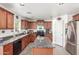 Classic kitchen features granite counters, wood cabinetry, stainless steel refrigerator, and an island at 28071 N Superior Rd, San Tan Valley, AZ 85143