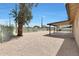 Spacious gravel backyard offering a covered patio area and shaded by a large tree near the fence at 3245 N 43Rd N Ave, Phoenix, AZ 85031