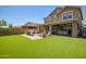 Expansive backyard featuring artificial grass, a covered patio and built-in BBQ area at 33275 N 132Nd Ave, Peoria, AZ 85383