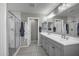 Bathroom featuring double sinks, a tiled shower with glass doors, and decorative tile flooring at 33275 N 132Nd Ave, Peoria, AZ 85383