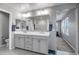 Bright bathroom with double vanity, decorative mirrors, and access to the shower and commode areas at 33275 N 132Nd Ave, Peoria, AZ 85383