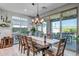 Bright dining room with wooden table, chairs, and stylish lighting fixtures, flowing to outdoor patio at 33275 N 132Nd Ave, Peoria, AZ 85383